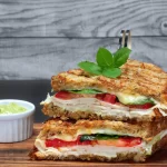 Lanche digno de cafeteria e fácil de fazer em casa! Esse sanduíche de frigideira com molho pesto e parmesão tem sabores marcantes e uma crostinha irresistível.