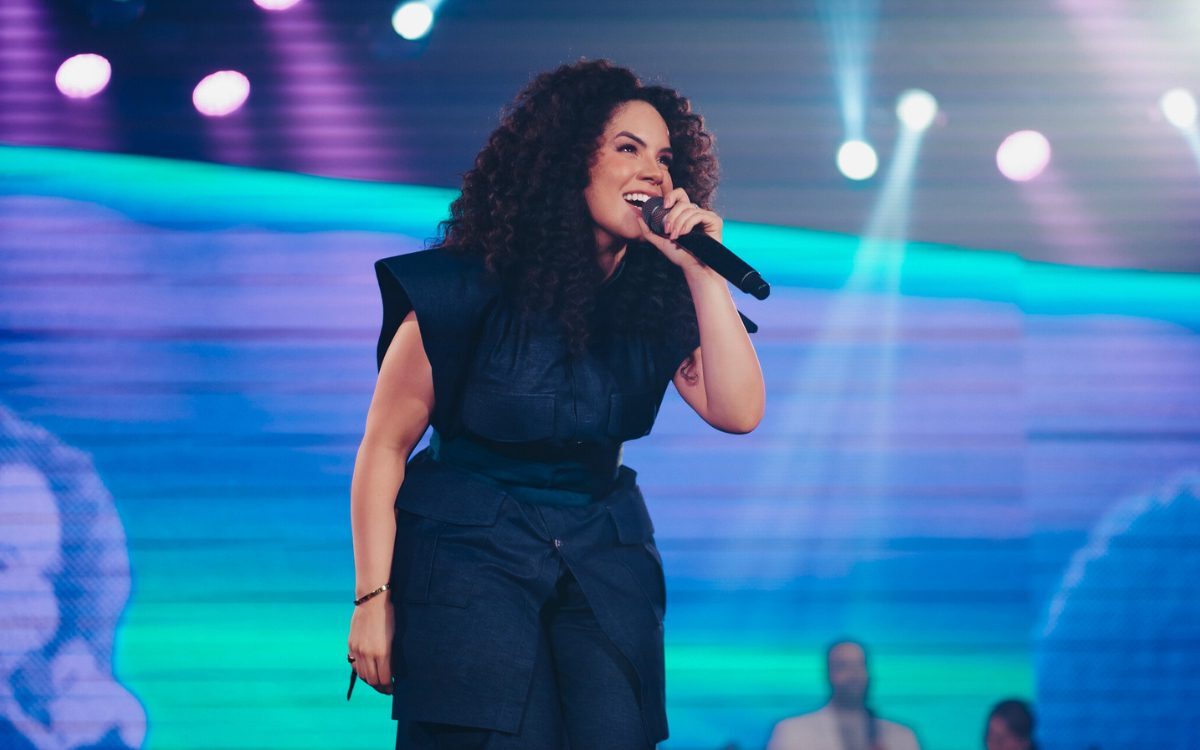 Com mais de um milhão de seguidores nas redes sociais e 15 anos de ministério, a cantora gospel Rebeca Carvalho presenteia seus fãs com o DVD “Águas Vivas”, gravado em dezembro do ano passado. À Comunhão, ela falou sobre esse novo projeto, que representa uma nova fase para a sua carreira, conforme ela destaca. “Nesses anos eu tenho visto a prosperidade da parte do Senhor, no sentido de ver testemunhos e milagres de testemunhar o que Ele tem feito através da minha voz, música e canção”, afirma Rebeca. Para ela, a grande conquista do seu ministério se traduz em testemunhos, milagres e transformações de vidas alcançadas. Igualmente, o projeto ao vivo é a materialização de um sonho antigo e a prova de que a constância na fé leva à abundância. “Essa nova fase eu posso definir como uma fase de surpresas e de realizações”, revela Rebeca. - Publicidade - A jornada de Rebeca foi pavimentada por desafios diários, desde a venda de frango assado para financiar seu primeiro CD até as adaptações ao mercado digital. “A carreira é sempre pautada de muitos desafios, sobretudo o maior é o que está conosco, então todos, todos os nossos desafios são regados de vitórias da parte do Senhor Deus”, complementa, mostrando a força de sua fé. Ela foi enfática ao afirmar que se pudesse dar um conselho à Rebeca do início de sua carreira, aos 12 anos de idade, ela seria enfática ao dizer: “Continue, não busque atalhos, assim como você tem feito, continue. O único atalho que você precisa é Jesus Cristo e ao seu tempo tudo vai acontecer”. A espera de 15 anos para lançar o DVD ao vivo não foi por acaso. “Minha carreira não é fruto de um vídeo viral na internet”, explica Rebeca, que passou por diversas fases, desde cantando em pequenas igrejas e superando desafios financeiros. “Fazer um projeto nesse tamanho, foi o tempo de Deus perfeito”, ressalta. Canções que marcam sua trajetória Em seu repertório, canções como “Bálsamo” (2020) e “Dependente” (2023) trazem grandes lembranças. “Dependente” foi escrita durante a pandemia, mas “Bálsamo”, sua primeira canção autoral lançada, guarda um testemunho especialmente marcante. Rebeca canta ao lado de Cassiane, em novo projeto "Águas Vivas". Foto: Divulgação. Rebeca canta ao lado de Cassiane, em novo projeto “Águas Vivas”. Foto: Divulgação. Rebeca recorda a história de uma mãe e filha no Rio de Janeiro que, em meio a um tiroteio em sua comunidade, viram um criminoso se refugiar em sua casa. A filha, que ensaiava “Bálsamo”, foi ouvida pelo assaltante, que pediu para que ela repetisse a canção. “Enquanto ela cantava, ‘em meio à dor, olho para o meu Senhor, é o meu bálsamo’, ele desistiu de fazê-las de refém”, conta Rebeca, emocionada. Para ela, a canção alcançou o homem e Jesus o libertou. Rebeca Carvalho enxerga o papel da música gospel como fundamental para influenciar a vida das pessoas. “Eu acredito que Cristo é a cura para todas as áreas. Quando eu trago Cristo em forma de canção, o resultado é a cura, o conforto, esse abraço que as pessoas precisam nesses dias tão aflitos e tão agitados, crises de pânico, síndrome do pânico, dias de ansiedades, quando nós temos a palavra de Deus nos sustentando, tudo fica mais leve”, reflete a artista. LEIA MAIS Pedro Nascimento em "No Nome de Jesus" (Ao Vivo). Foto: Reprodução / YouTube Pedro Nascimento. Pedro Nascimento finaliza EP com o single “No Nome de Jesus” Colaboração com Bispo Rinaldo marca a última faixa do projeto ao vivo de Pedro Nascimento, prometendo fortalecer a fé e a esperança Bunekão de Jesus "Ao vivo". Fotos: Uelber Souza e Elias Santana. Bunekão de Jesus lança álbum ao vivo gravado na Bahia "A Turma do Bunekão: O Show" celebra 20 anos de sucesso com a criançada e abre seus lançamentos ao vivo com a música "Pula Pula" Novo projeto Rebeca também já vislumbra novos horizontes para o futuro bem próximo da carreira. “Uma turnê do DVD “Águas Vivas” está planejada, com o objetivo de rodar o país e, quem sabe, o mundo”. A artista também afirmou que já termina um álbum planejando o próximo e que existem muitas expectativas para os próximos passos do seu ministério. Com o novo projeto “Águas Vivas”, a cantora não apenas celebra 15 anos de ministério, mas também reafirma seu compromisso em levar esperança e cura através da música. A faixa-título do novo projeto, “Águas Vivas” é inspirada no livro de João 4 e traz um testemunho emocionante de sua mãe. O processo de composição da canção com seus irmãos foi um momento de “muita comoção” e da “presença nítida do Espírito Santo”.