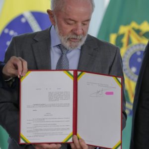 O presidente Luiz Inácio Lula da Silva (PT) assina o decreto que estabelece a Nova Política de Educação a Distância. A cerimônia realizada no Palácio do Planalto, em Brasília, com a presença do ministro da Educação, Camilo Santana. A medida determina novas regras para o funcionamento de cursos de graduação e pós-graduação oferecidos por instituições de ensino superior na modalidade a distância. 
O presidente mostrou e assinou o decreto com a caneta que teria sido perdida por 20 anos e que está  a procura de como consertar a parte danificada. | Sérgio Lima/Poder360 - 19.mai.2025